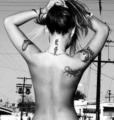 A girl's upper back was tattooed with a Christian cross with wings and' My